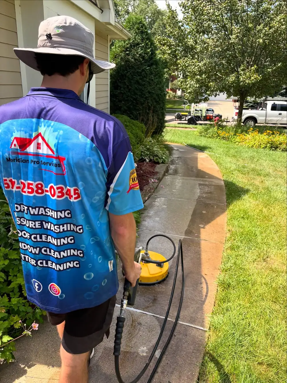 Pressure washing crew cleaning a concrete walkway in Dewitt, MI