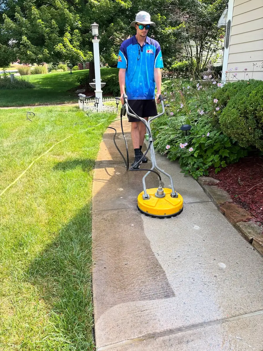 Surface cleaner pressure washing a walkway in Williamston, MI