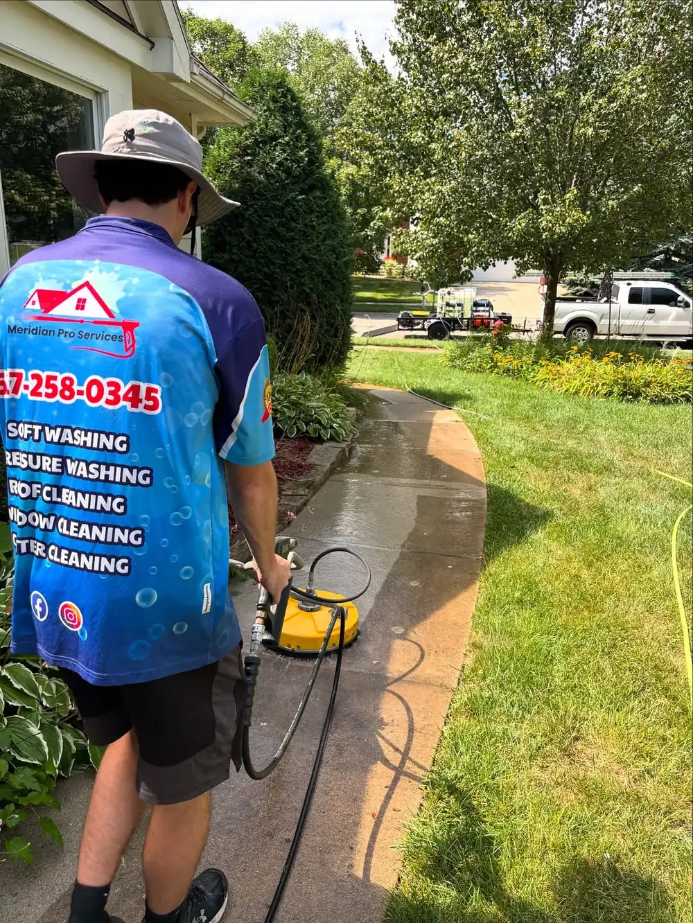 Meridian Pro Services crew pressure washing a walkway in Mason, MI