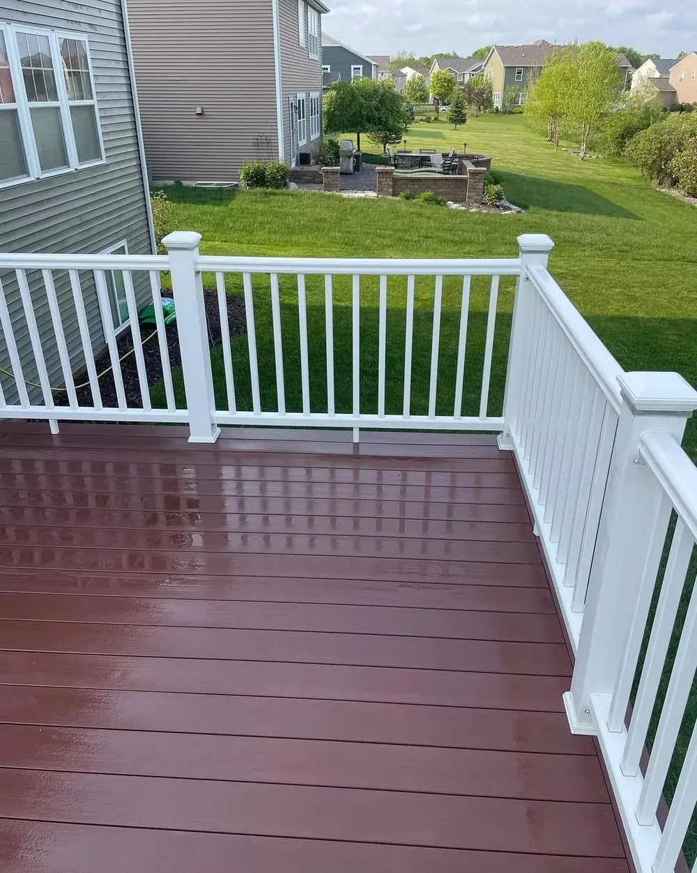 Red painted deck with white railing after deck and fence cleaning in Okemos, MI
