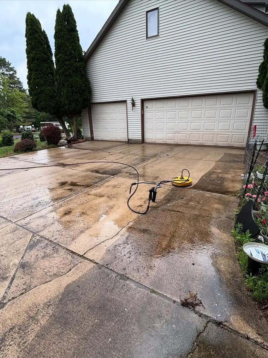 Professional pressure washing a concrete driveway in Okemos, MI