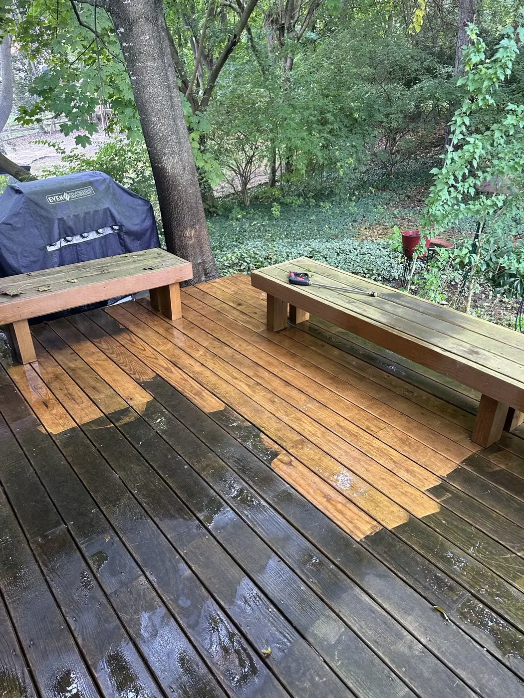 Wood deck mid-clean, showing the line between freshly cleaned boards and the weathered, dirty surface